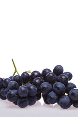 Fresh grape cluster on white with water drops