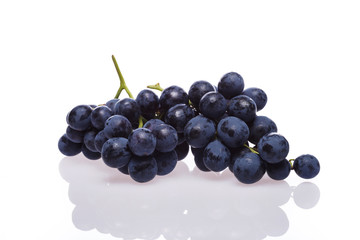 Fresh grape cluster on white with water drops