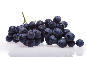 Fresh grape cluster on white with water drops