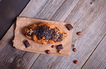Chocolate croissant on wooden background