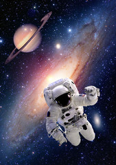 Astronaut spaceman suit outer space saturn planet milky way universe. Elements of this image furnished by NASA. © nikonomad