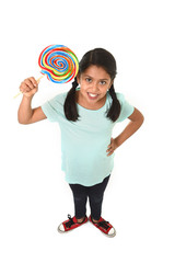happy latin female child holding big lollipop candy in loving sweet face expression