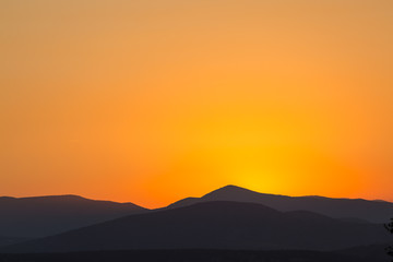 Scenic view of a beautiful rich orange sunset over the mountains