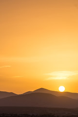 Scenic view of a beautiful rich orange sunset over the mountains