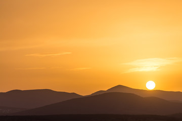 Scenic view of a beautiful rich orange sunset over the mountains