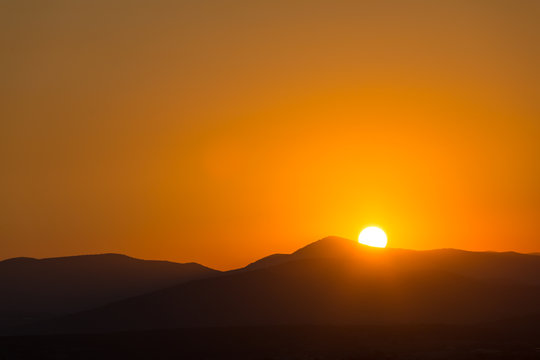 Scenic View Of A Beautiful Rich Orange Sunset Over The Mountains