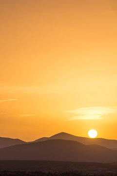 Scenic View Of A Beautiful Rich Orange Sunset Over The Mountains