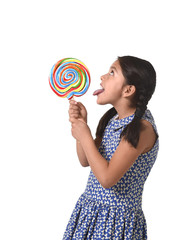 happy female child holding big lollipop licking the candy with her tongue in sugar addiction