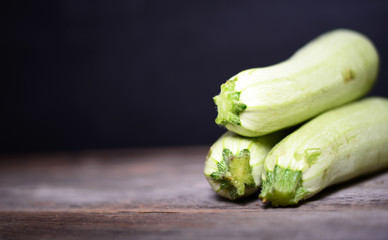 Fresh zucchinis on wood background