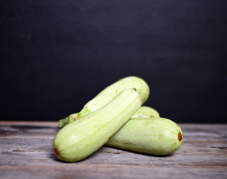 Fresh zucchinis on wood background