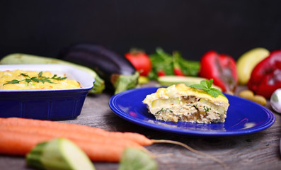 Healthy zucchini lasagna bologneseon blue plate and baking dish