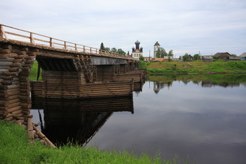 Old wooden bridge across the river. North Russia