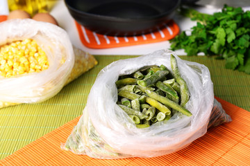 Frozen vegetables in bags on kitchen table close up