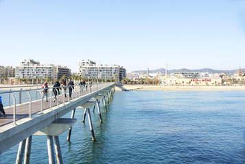Fototapeta na wymiar Puente mirador sobre las aguas de la playa de Badalona, Barcelona