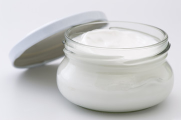 Glass jar with body cream isolated on white background