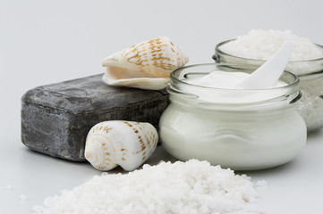Cream jar, mud soap and sea salt isolated on white background