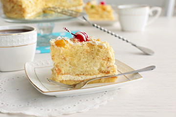 Peace of tasty Butter cake on plate, tea cups on color wooden background
