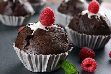 Delicious chocolate cupcakes with berries on table close up