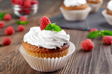 Delicious cupcake with berries and fresh mint on wooden table close up