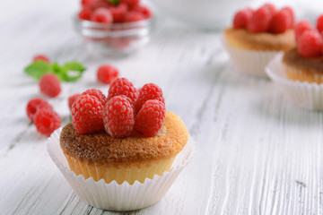 Delicious cupcakes with berries and fresh mint on wooden table close up