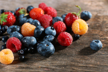 Heap of sweet tasty berries on wooden table close up