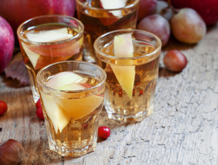 Apple juice with slices of fresh apples in the autumn background