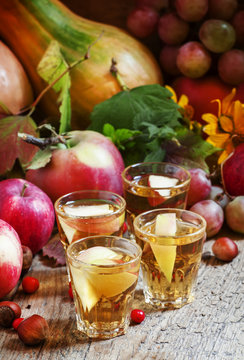 Apple juice with slices of fresh apples in the autumn background