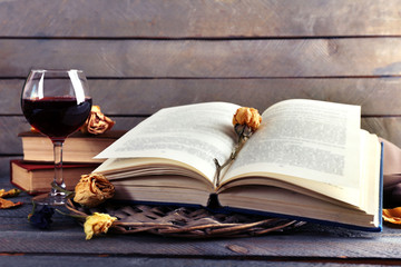 Beautiful composition with glass of wine with old books on table close up