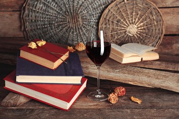 Beautiful composition with glass of wine with old books on table close up