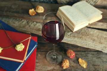 Beautiful composition with glass of wine with old books on table close up