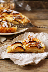 Piece of homemade apple pie on wooden background