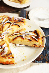 Homemade apple pie on plate, on white wooden table background background