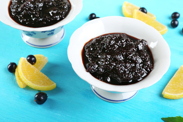Tasty currant jam with berries on table close up