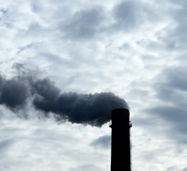 Smoke from smokestack of industrial factory pollutes air 