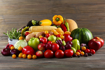 Heap of fresh fruits and vegetables on wooden background