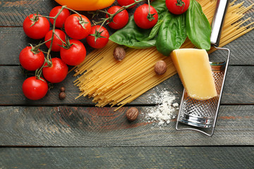 Pasta spaghetti with tomatoes, cheese and basil on rustic wooden  background