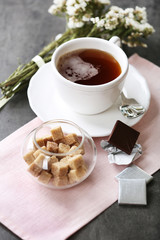 Cup of flavored coffee with chocolate on table with napkin, closeup