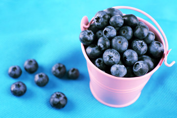 Tasty ripe blueberries in bucket on table close up