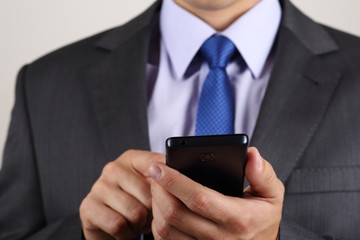 Close up of business man hands holding mobile phone