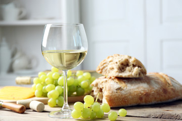 Still life of wine, grape, cheese and bread on light background