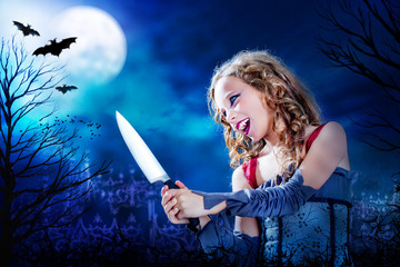 Young vampire with knife at full moon.