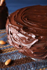 appetizing chocolate cake among almonds on blue background