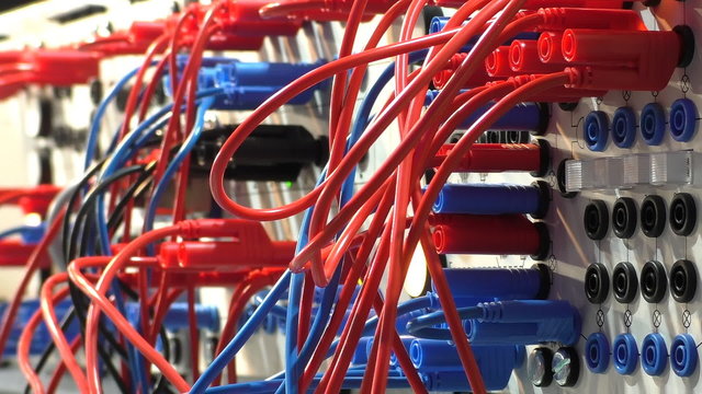 Close up of network control panel with many wire connections and lights blinking