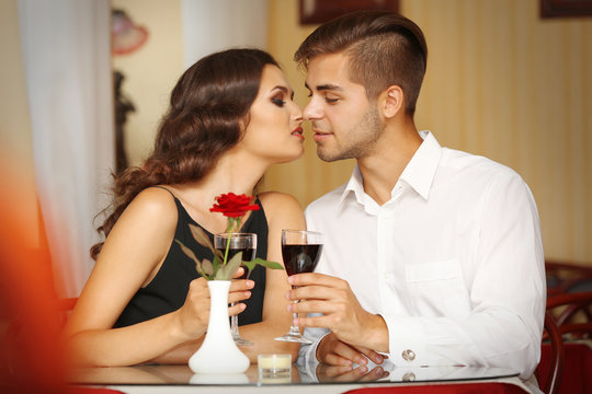 young attractive lady kisses her beloved man at the restaurant
