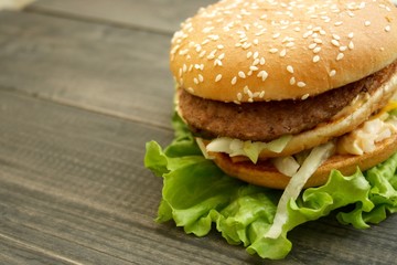 Hamburger and fries on a wooden cutting board