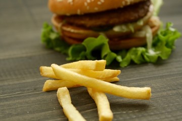 Hamburger and fries on a wooden cutting board
