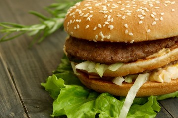 Hamburger and fries on a wooden cutting board