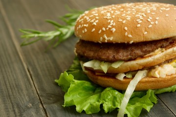 Hamburger and fries on a wooden cutting board