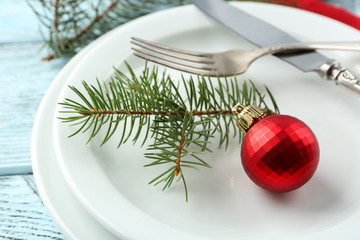 Empty plate, cutlery, napkin and glass on rustic wooden background. Christmas table setting concept