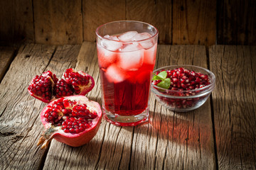 Pomegranate with and pomegranate juice on wooden background